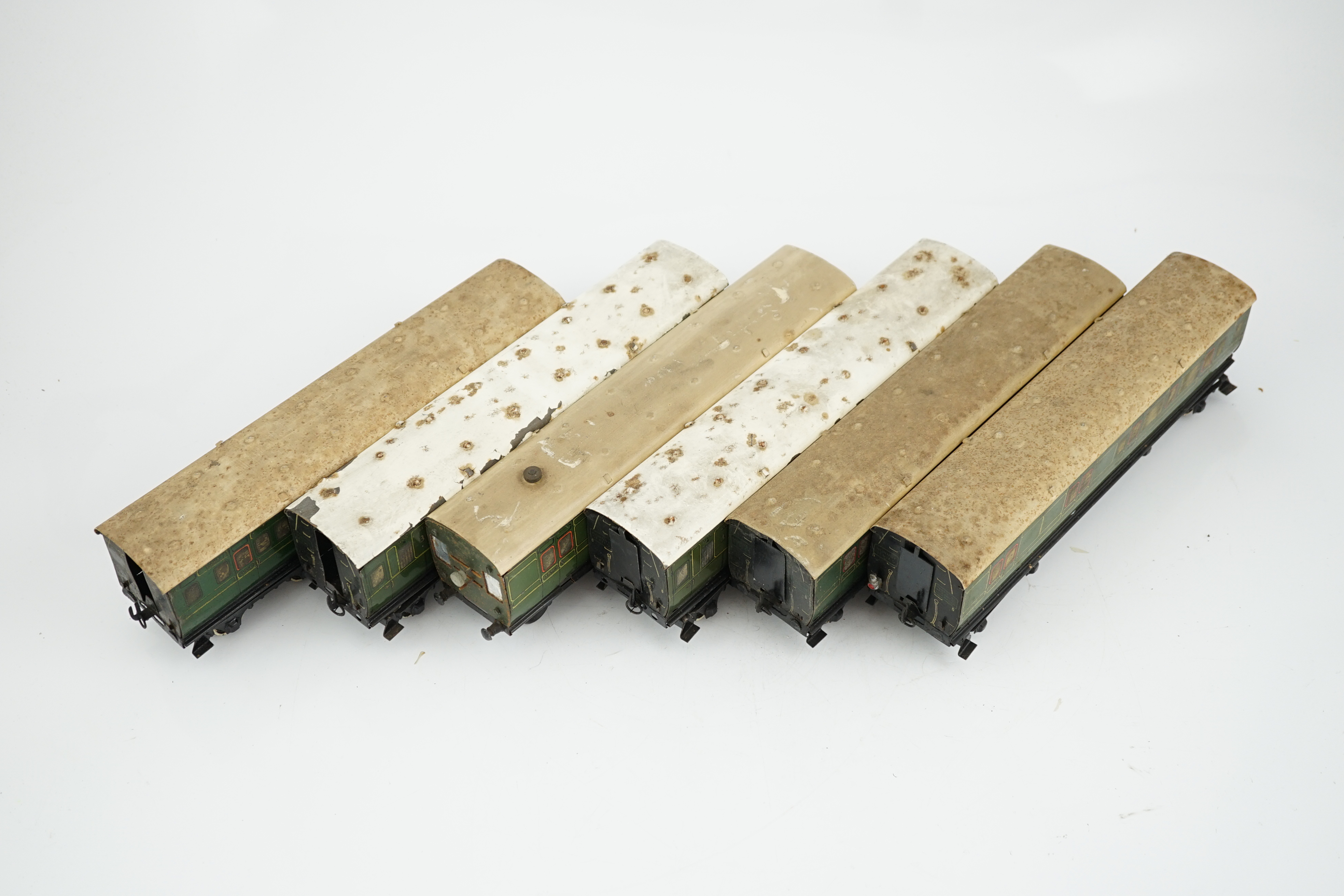 Six Hornby 0 gauge tinplate No.2 coaches in Southern Railway livery, one coach adapted to a driving unit with clockwork motor and replacement bogie